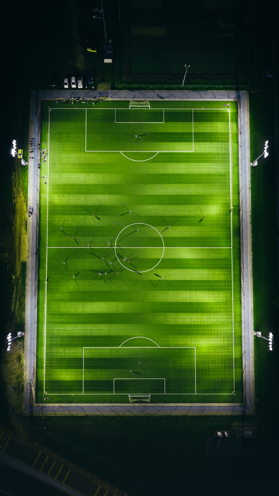 Lapangan sepak bola dengan lampu stadion menyala